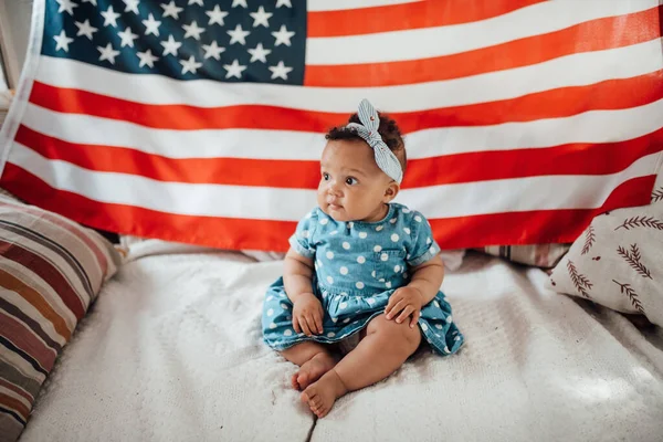 Krásná Holčička Modrých Šatech Sedí Pohovce Americkou Vlajkou Pozadí — Stock fotografie