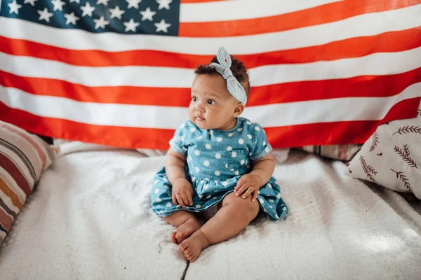 Krásná Holčička Modrých Šatech Sedí Pohovce Americkou Vlajkou Pozadí — Stock fotografie