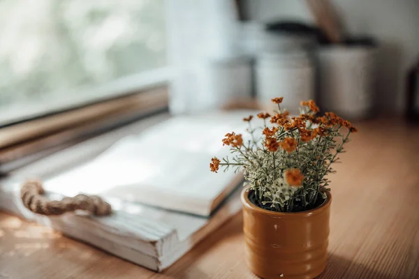 Little pot with flowers on table, blurred background