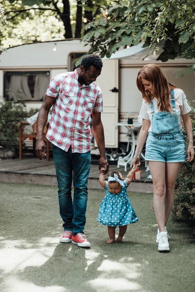 昼間の夏の公園でかわいい女の子と一緒に幸せな家族の散歩 — ストック写真