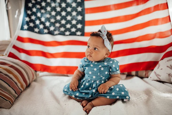 Preciosa Niña Vestido Azul Sentada Sofá Con Fondo Bandera Americana — Foto de Stock