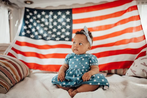 Krásná Holčička Modrých Šatech Sedí Pohovce Americkou Vlajkou Pozadí — Stock fotografie