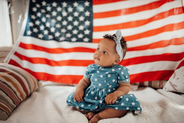 Preciosa Niña Vestido Azul Sentada Sofá Con Fondo Bandera Americana — Foto de Stock