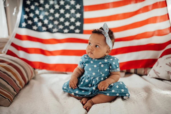 Preciosa Niña Vestido Azul Sentada Sofá Con Fondo Bandera Americana — Foto de Stock