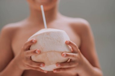 Küçük şirin çocuk yazın hindistan cevizi suyu içiyor. 