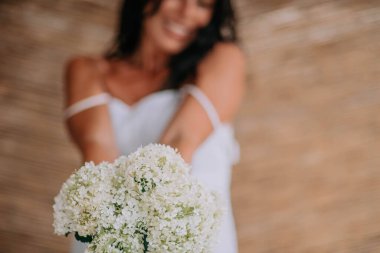 Beyaz çiçekli beyaz elbiseli gelinin kırpılmış görüntüsü 