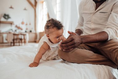 Baba Bebek Bağlantısı. Mutlu siyahi adam evde tatlı bebekle bağ kuruyor.