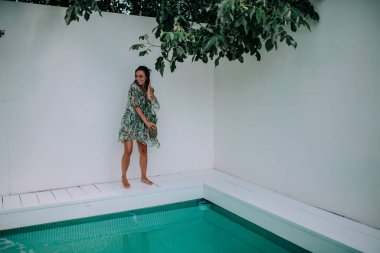 Yüzme havuzunun yanında ananas pozu veren bir model. 