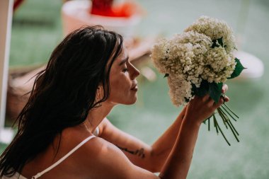 Beyaz elbiseli gelin elinde çiçekler 