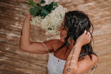 Beyaz elbiseli gelin elinde çiçekler 