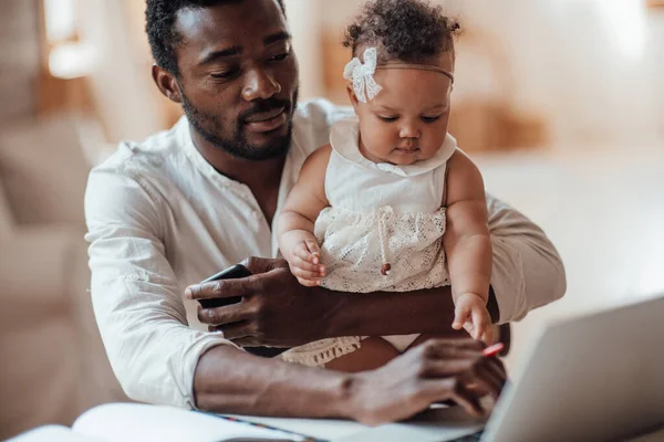 Homem Negócios Africano Trabalhando Casa Laptop Enquanto Segurava Filha — Fotografia de Stock