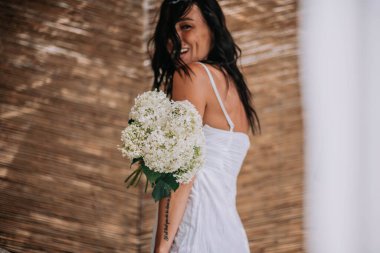 Beyaz elbiseli gelin elinde çiçekler 