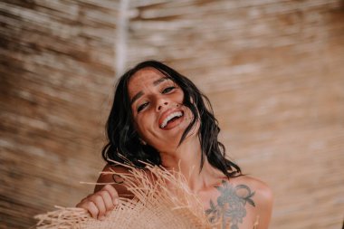 Hasır şapka tutan kadın modelin portresi