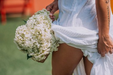 Beyaz çiçekli beyaz elbiseli gelinin kırpılmış görüntüsü 