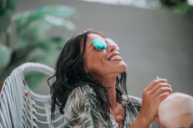 Mutlu esmer kız kokteyl içiyor ve dışarıda takılıyor. 