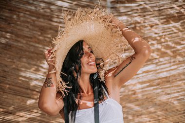 Hasır şapkalı ve elbiseli kadını kapat.