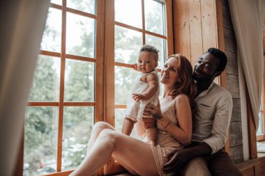 Evde pencerenin yanında kızı olan çift