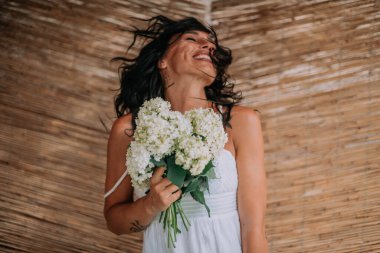 Beyaz elbiseli gelin elinde çiçekler 