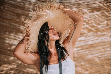 Hasır şapkalı ve elbiseli kadını kapat.