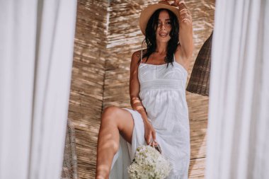 Hasır şapkalı ve elbiseli mutlu kız.