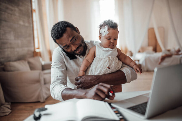 father working from home with daughter on hands