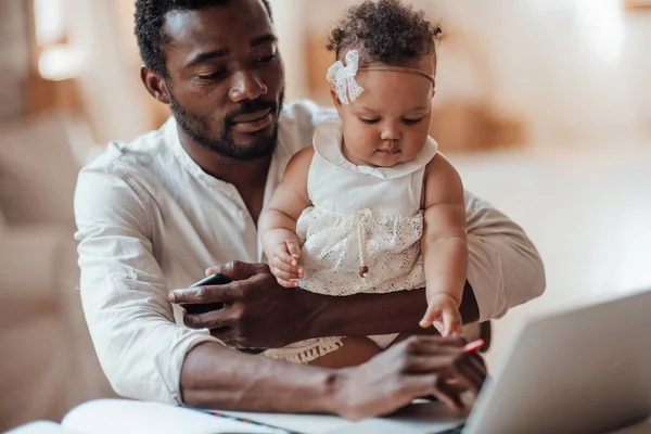 Jovem Homem Africano Trabalhando Segurando Menina Casa — Fotografia de Stock