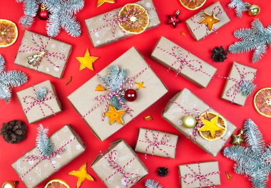 Kırmızı arka planda bir sürü ekolojik hediye kutusu var. Noel el yapımı kağıt kaplama bezi düz yatıyordu