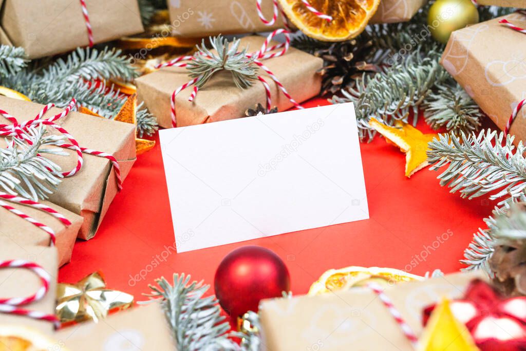 New year gift card, visitcard mockup with many presents and christmas decor on red background. Holiday packaging border with pine tree branch, wrapped paper boxes. Greetings template, space for text