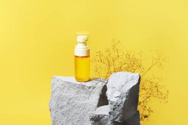 Sarı arka planda gri beton taş podyumda pompalı serum kozmetik şişesi. Yılın 2021 rengi posteri, afiş şablonu. Moda doğal güzellik ürün sunum konsepti, kopyalama alanı