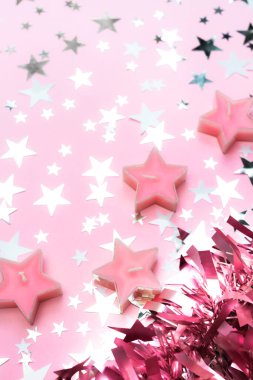 Pembe süslemeli dekor arka planı. Noel, yeni yıl şablonu yıldız konfetileri, mumlar ve fotokopi alanı. Bayram selamlama afişi, gül altın metalik dekor klip