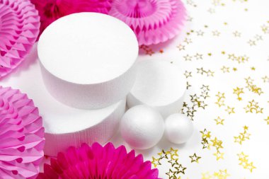 Birçok beyaz kaide podyumu sergileniyor. Yuvarlak pembe kağıt süsleme. Doğum günün kutlu olsun, yeni yıl partisi geçmişi. Noel Tatili Dekoru.