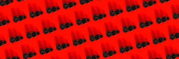 Coni di pino sul modello di sfondo rosso. Buon Natale Concetto creativo di Capodanno. — Foto Stock