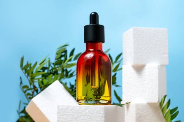 Mavi Arkaplanda Pipette 'li Kozmetik Şişe. Güzellik konsepti. Meydan Küp Podyumu