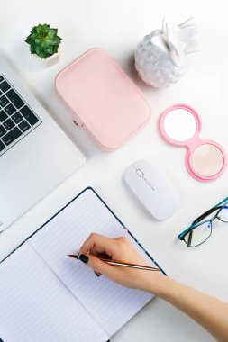 Kadın dizüstü bilgisayara yazar ve bilgisayarda çalışır. Beyaz arka planda rahat bir bayan çalışma alanı. Ev ofisini düzleştir