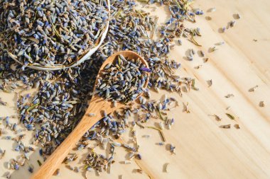 Tahta masada kaşıkla kurutulmuş lavanta. Bitkisel içecek. Güzellik kozmetiği, parfüm malzemesi. Rahatlama içeceği