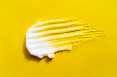 Sarı arka planda beyaz köpük lekesi. Kişisel bakım prosedürünün kozmetik ürünü. Güzellik makro kabarcık dokusu. Yılın moda rengi izole krem, tıraş köpüğü, maske, güzellik ürünü kumaş örneği yakın çekim.