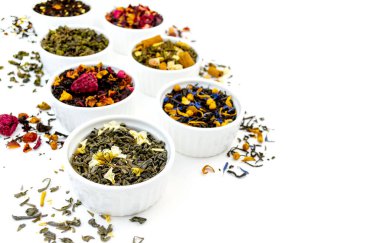 Beyaz arka planda izole edilmiş bir sürü kuru çay var. Kırmızı, meyve, yeşil, siyah ve bitkisel yapraklar kurutulmuş taze tatlı içeceği sancak şablonu. Organik içecek. Yakın çekim.