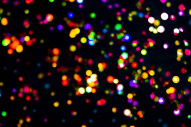 Gece renkli şehir açık siyah örtülü arka plan. Parıltı dağılmış, holografik bokeh ışını. Parlak noel süslemesi soyut bulanık bokeh etkisi. Yeni yıl holo ışık yansıması. Şenlikli duvar kağıdı