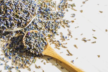 Tahta masada kaşıkla kurutulmuş lavanta. Bitkisel içecek. Güzellik kozmetiği, parfüm malzemesi. Rahatlama içeceği