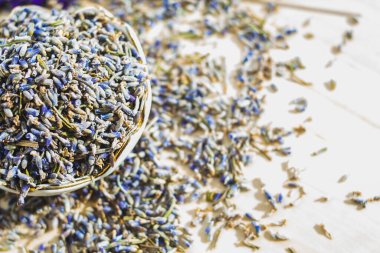 Porselen kâse, arka planda bulanık, kurutulmuş lavanta renkli, makro pankartlı. Çiçekli bitki çayı malzemesi.