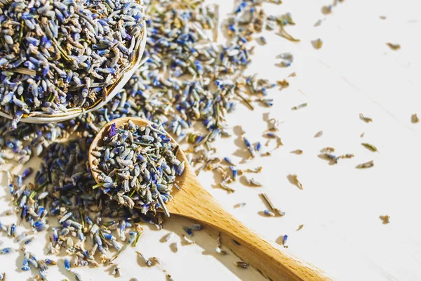 Tahta masada kaşıkla kurutulmuş lavanta. Bitkisel içecek. Güzellik kozmetiği, parfüm malzemesi. Rahatlama içeceği