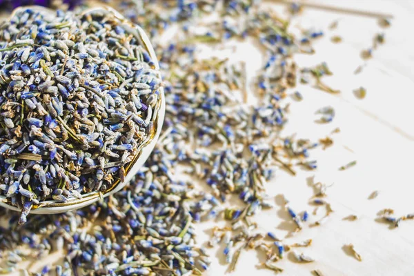 Porselen kâse, arka planda bulanık, kurutulmuş lavanta renkli, makro pankartlı. Çiçekli bitki çayı malzemesi.