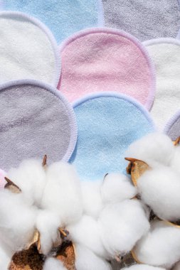 Kozmetik yıkanabilir pastel renkli pamuklu süngerler beyaz arka planda torbaya konur. Doğal temizlik, makyaj yastığı ve kurumuş pamuk. Kumaş cilt bezi. Güzellik sıfır atık kavramı.