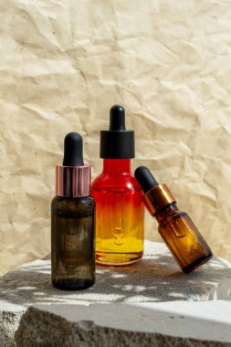 Üç Pipette Şişesi Temel Yağ, gri taş podyumda Serum modeli, bej el işi kağıt arka plan. Güzellik damgası boş kaplar. Somut sunum kaidesi ve brunch gölgesi