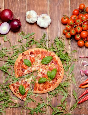 Homemade fresh pizza served on wooden table.