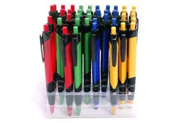 Ballpoint pens in holders on white background.