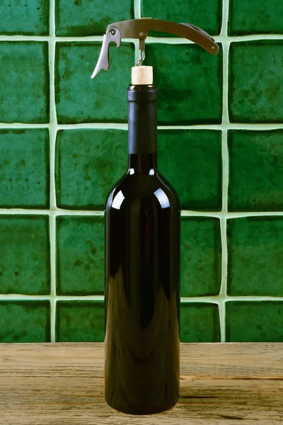 녹색 배경 위에 코르크와 레드 와인의 병. — 스톡 사진