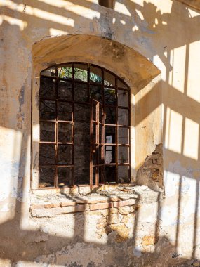 Terk edilmiş bir kalenin paslı bir penceresinin resmi.