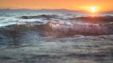 red sun rises over blue waves at morning shore on summer vacation