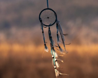 close up view of dream catcher by air at sunset